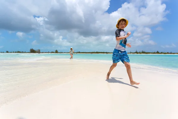 Stylish boy running on a tropical beach — Stock Photo, Image