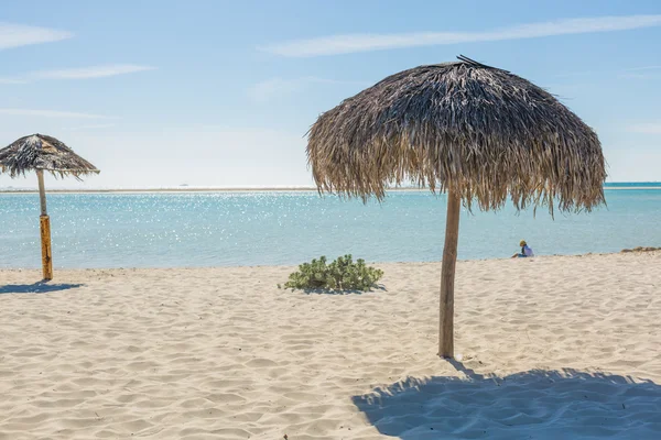 Guarda-chuva de praia feito de folhas de palma na praia exótica — Fotografia de Stock