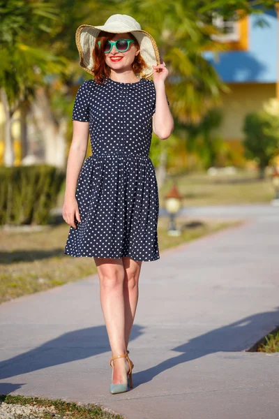 Young woman in polka-dot dress and straw hat — Stock Photo, Image