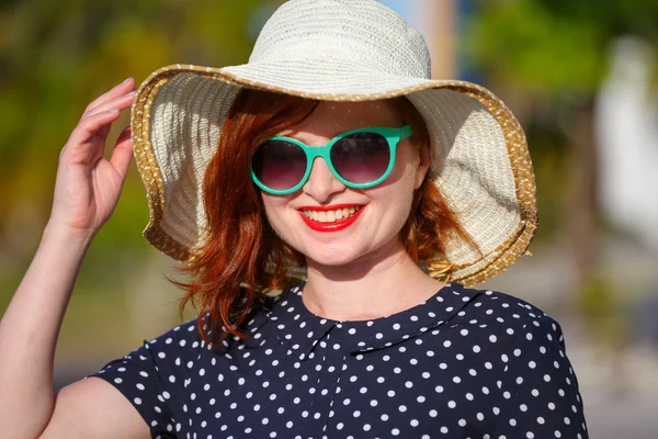 Young woman in polka-dot dress and straw hat — Stock Photo, Image