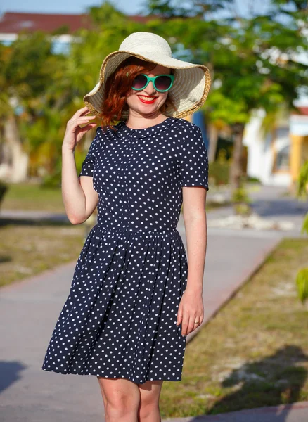 Young woman in polka-dot dress and straw hat — Stock Photo, Image