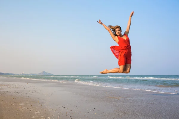 점프 하는 빨간 드레스에 섹시 한 여자 — 스톡 사진