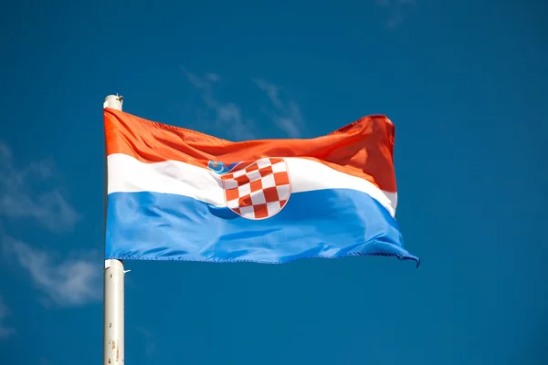 Vlajka Chorvatska proti modré obloze — Stock fotografie