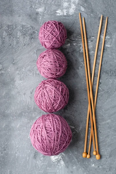 Four Large Balls Purple Wooden Needles Gray Textured Concrete Background — Stock Photo, Image