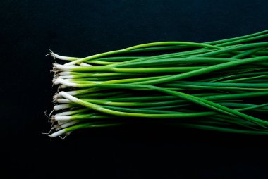 Bir avuç genç çevre dostu çiftlik soğanı. Karanlık bir anahtarın içinde fotoğraf. Yazı için yer.