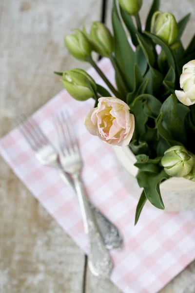 Bouquet of delicate pink tulips on the tablecloth and two forks — Stock Photo, Image
