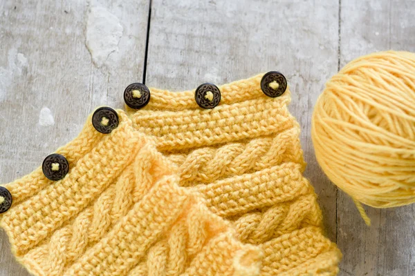 Modèle de tricot et boule sur un fond en bois — Photo