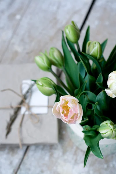 Strauß zarter rosa Tulpen und Nadeln zum Stricken auf einem hölzernen Hintergrund — Stockfoto