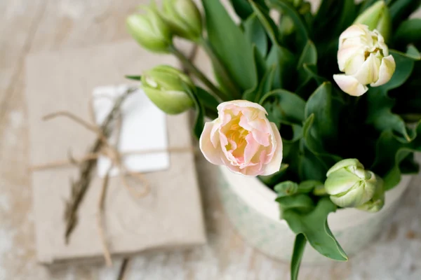 Bouquet of delicate pink tulips and needles for knitting on a wooden background — Stock Photo, Image