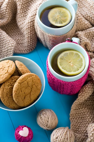 Two blue cup of tea in knitted sweater with hearts felt standing — Stock Photo, Image