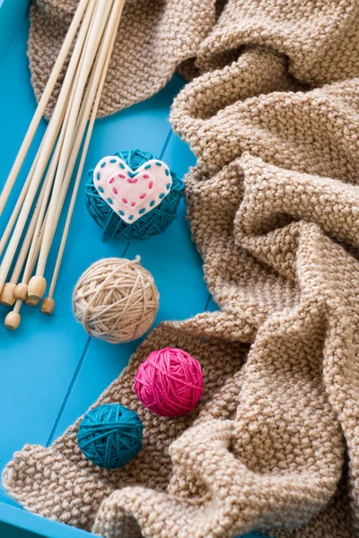 Wooden needles lie next to the bright tangle of threads and knit — Stock Photo, Image
