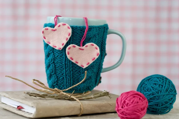 Blaue Tasse im blauen Pullover mit Filzherzen — Stockfoto