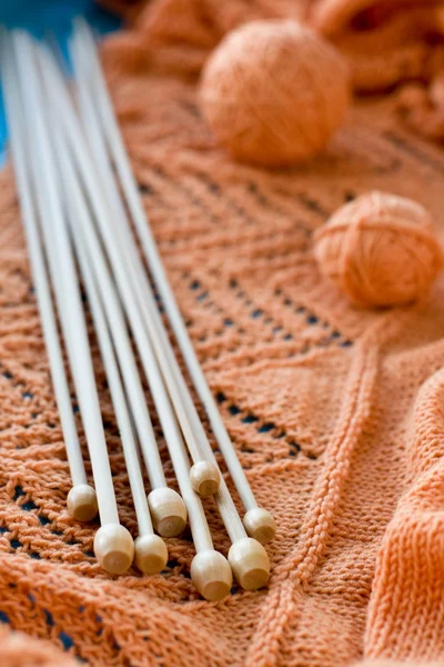 Molti raggi di legno si trovano su un plaid lavorato a maglia arancione — Foto Stock