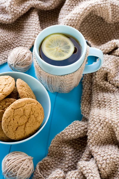 En kopp te med citron, kex, beige stickad filt lögn på — Stockfoto