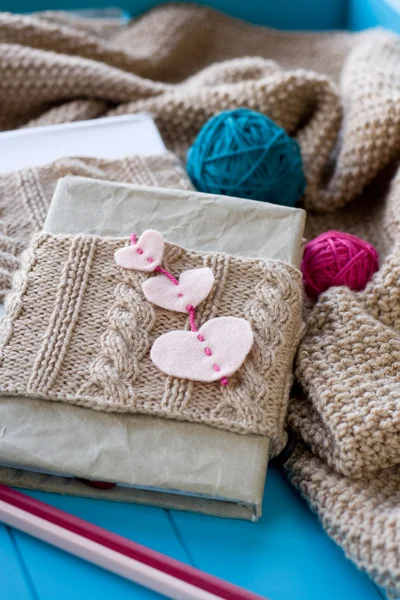 Ein altes Notizbuch in Strickhülle mit Filzherzen liegt neben mir — Stockfoto