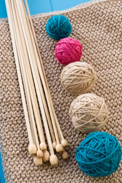 Colorful balls and wooden needles lying on beige — Stock Photo, Image