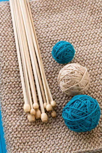 Tre palline colorate e aghi di legno sdraiato sul beige p maglia — Foto Stock