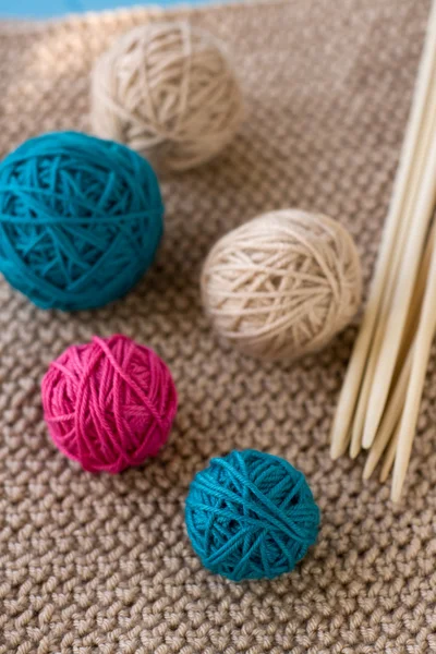 Bolas coloridas y agujas de madera tumbadas en beige —  Fotos de Stock