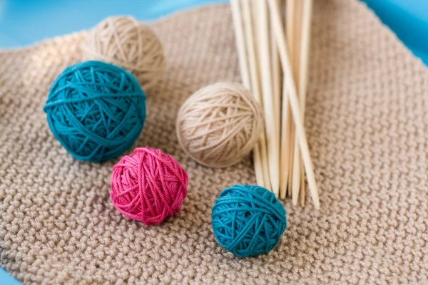 Colorful balls and wooden needles lying on beige — Stock Photo, Image