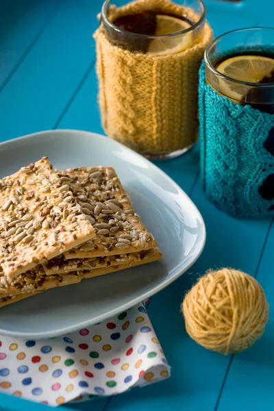 Duas xícaras de chá delicioso em suéter de malha amarelo na parte de trás azul — Fotografia de Stock