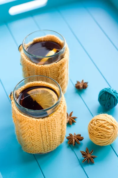 Two cups of tea in yellow Knitted sweaters on blue background — Stock Photo, Image