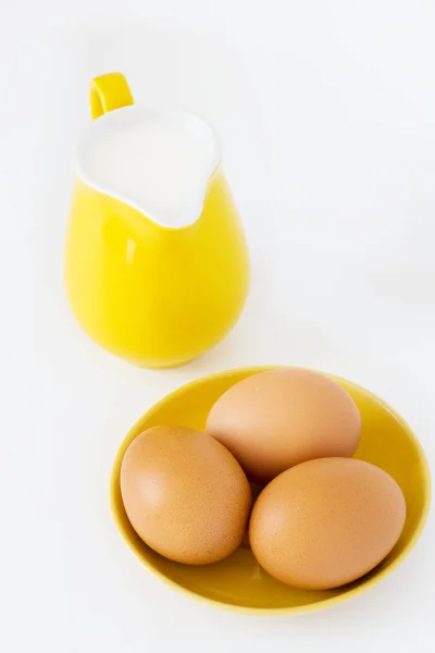 用牛奶、 鸡蛋在白色背景上的黄色水罐 — 图库照片