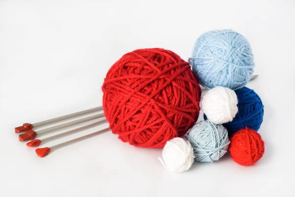 Bolas coloridas e agulhas para tricotar deitado em um backgro branco — Fotografia de Stock