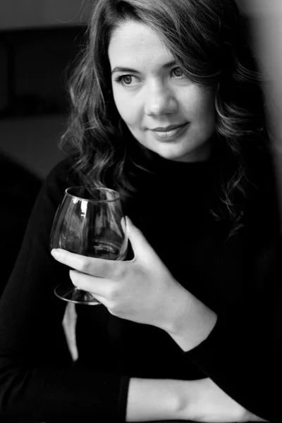Hermosa joven morena rizada sosteniendo un vaso con alcohol — Foto de Stock