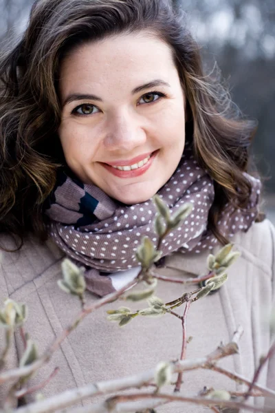 Portret van een jonge mooie curly brunette in beige vacht en s — Stockfoto