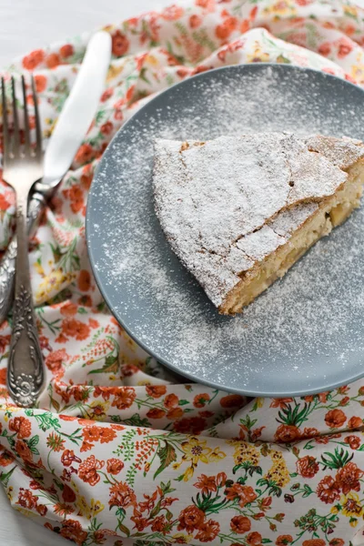 Um pedaço de torta de maçã deitado no prato cinza, faca e garfo em — Fotografia de Stock