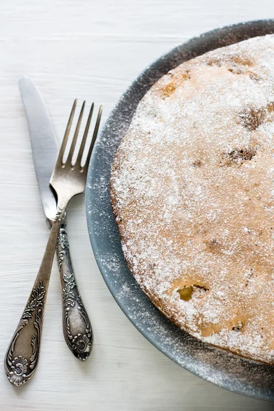 Яблочный пирог серая тарелка, лежащая рядом вилка и нож на белой нитке — стоковое фото