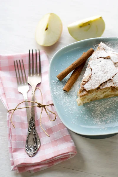 Un pezzo di torta di mele sdraiato sul piatto blu, mela, bastoncini di cannella — Foto Stock