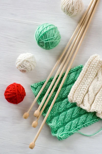 Dois padrões brilhantes, bolas de fios e agulhas para tricotar madeira — Fotografia de Stock