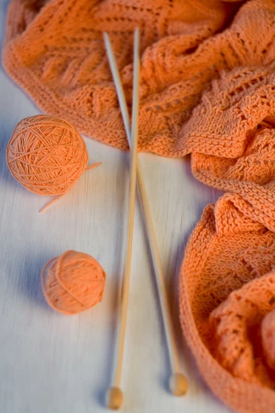 Carreaux orange vif tricotés, aiguilles à tricoter et boules de fil — Photo