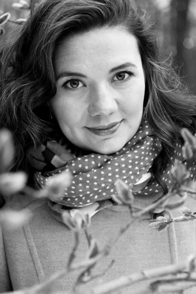 Portrait of a young beautiful curly brunette in beige coat and s — Stock Photo, Image