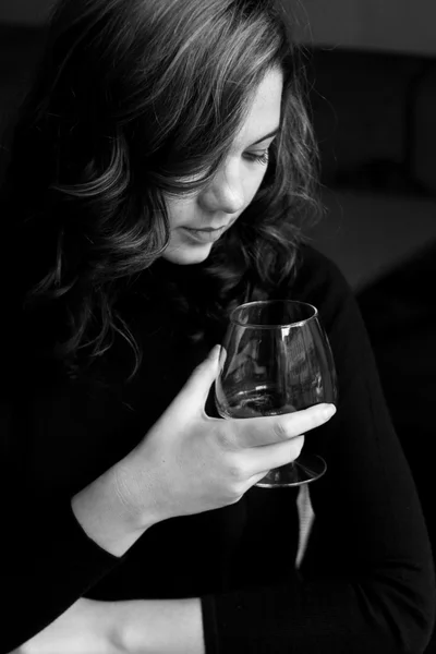 Красивая юная кудрявая брюнетка держит стакан с алкоголем — стоковое фото