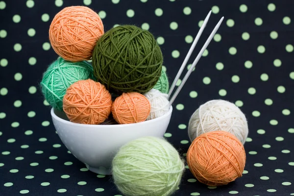 Um monte de bolas brilhantes para tricotar em um fundo escuro — Fotografia de Stock