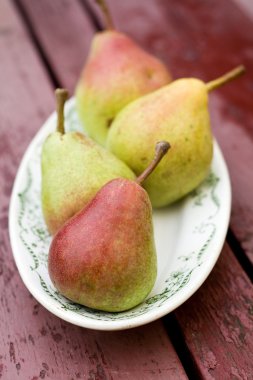 Olgun tatlı armut beyaz bir plaka üzerinde yalan