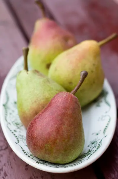 Pera dulce madura acostada en un plato blanco —  Fotos de Stock