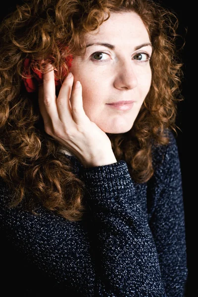 Portrait of beautiful young redhead with curly red rose in her h — Stock Photo, Image