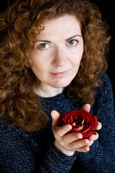 Portret piękny młody rude kręcone Red rose w ręku — Zdjęcie stockowe