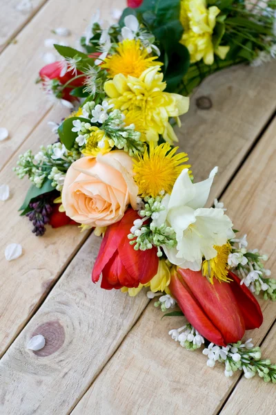 Bouquet of colorful spring flowers lying on the unpainted wooden — Stock Photo, Image