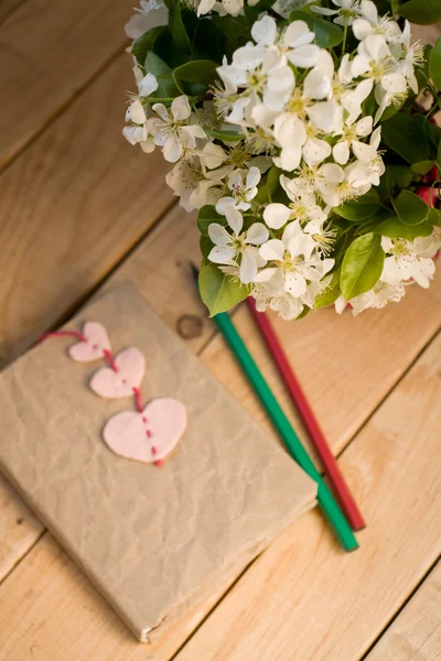 Un ramo de flores blancas de primavera y un viejo cuaderno vintage con — Foto de Stock
