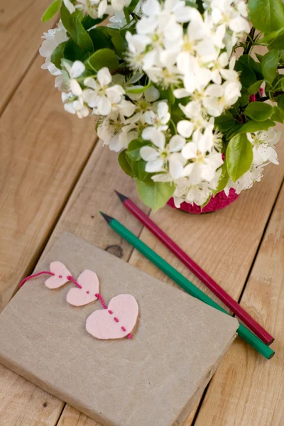 Kytice bílých jarních květin a staré vinobraní notebook s — Stock fotografie