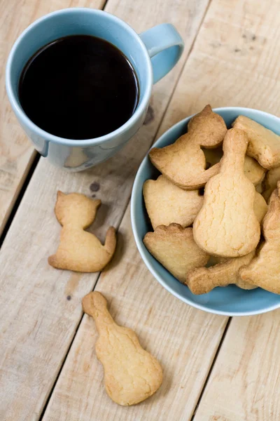 Sladké chutné cookies v modré desky a šálek černé kávy — Stock fotografie