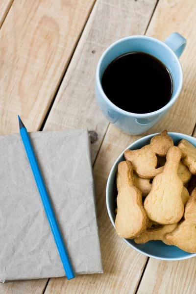 Süße leckere Kekse auf dem blauen Teller, eine Tasse schwarzen Kaffee — Stockfoto