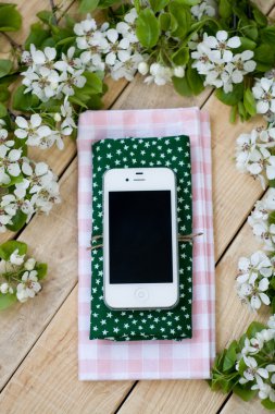 Beyaz smartphone bir ahşap arka plan üzerinde yalan