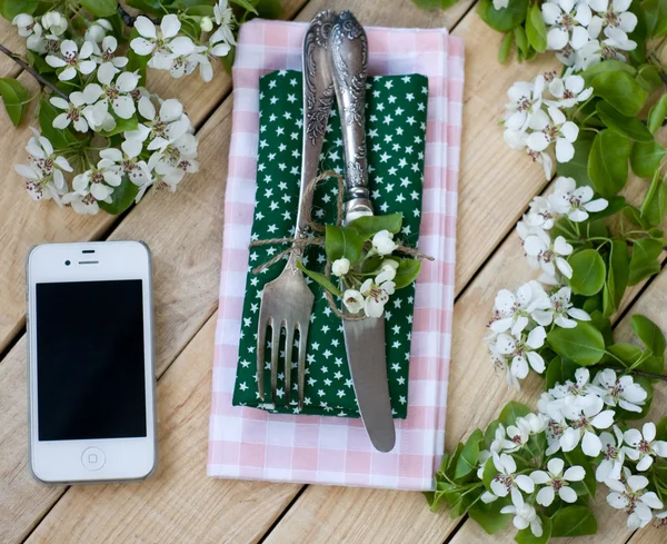 Tenedor y cuchillo, teléfono inteligente blanco acostado sobre un fondo de madera — Foto de Stock