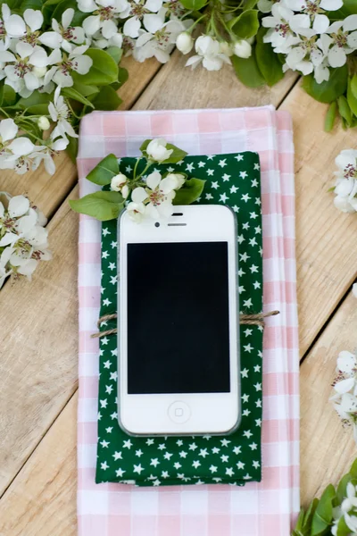 Белый смартфон лежит на деревянном фоне — стоковое фото