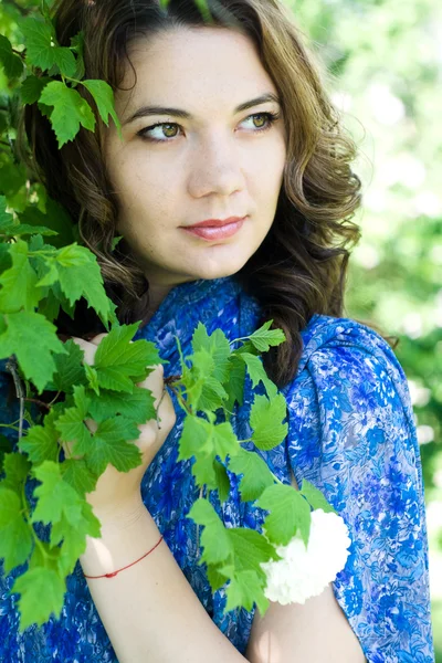 La fille dans une robe bleue tenant une branche avec des fleurs blanches — Photo